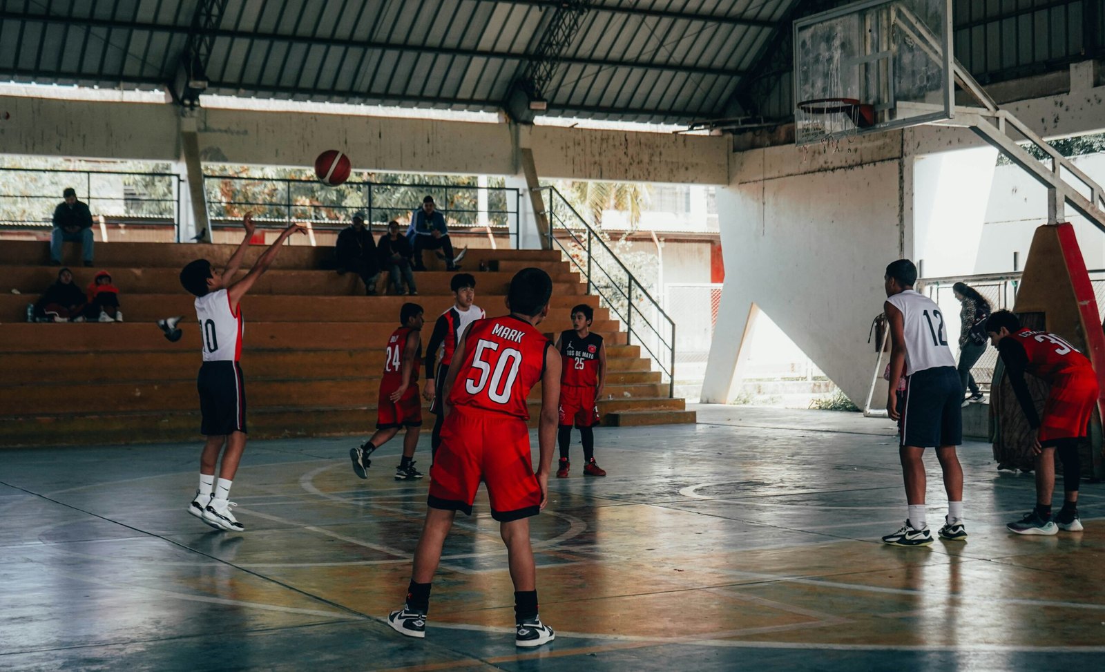 Youth basketball team practising together in a school gym