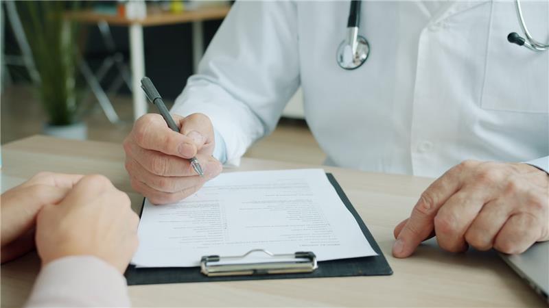 Doctor writing on a patient’s chart